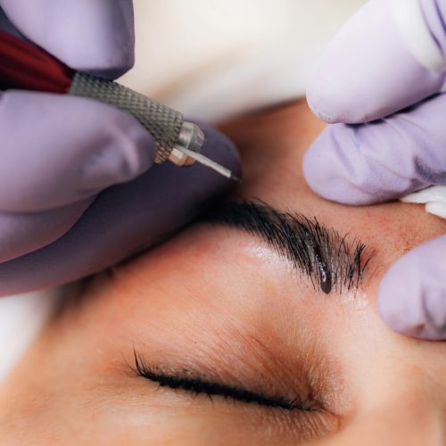 Beautician Microblading Eyebrows in Beauty Salon